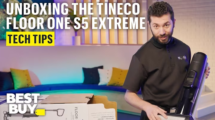 Text reads: "Unboxing the Tineco Floor One S5 Extreme. Tech Tips. Best Buy." A Geek Squad agent is holding a floor washer.
